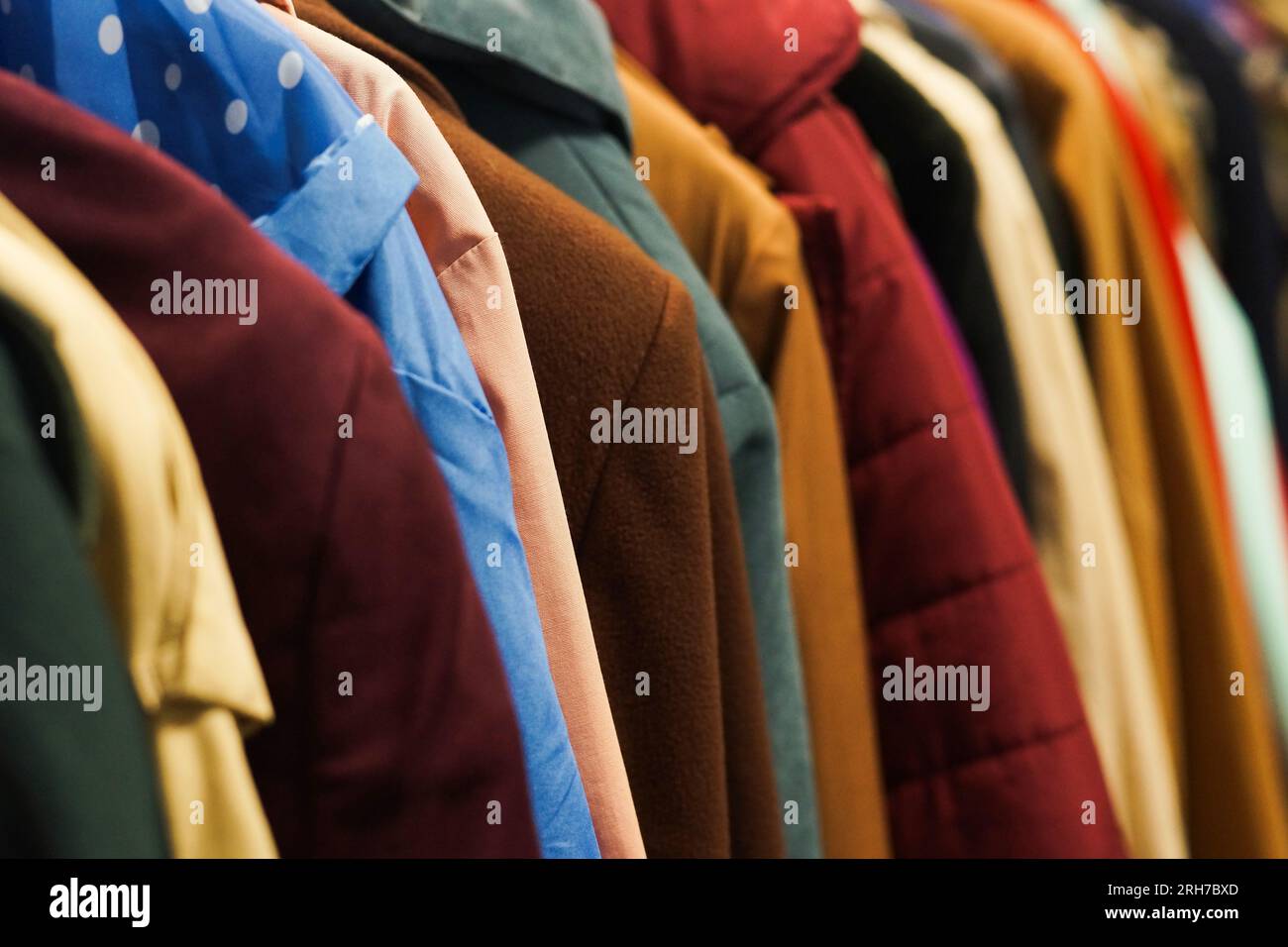 Rack with colourful coats. Charity second hand clothes. Stock Photo