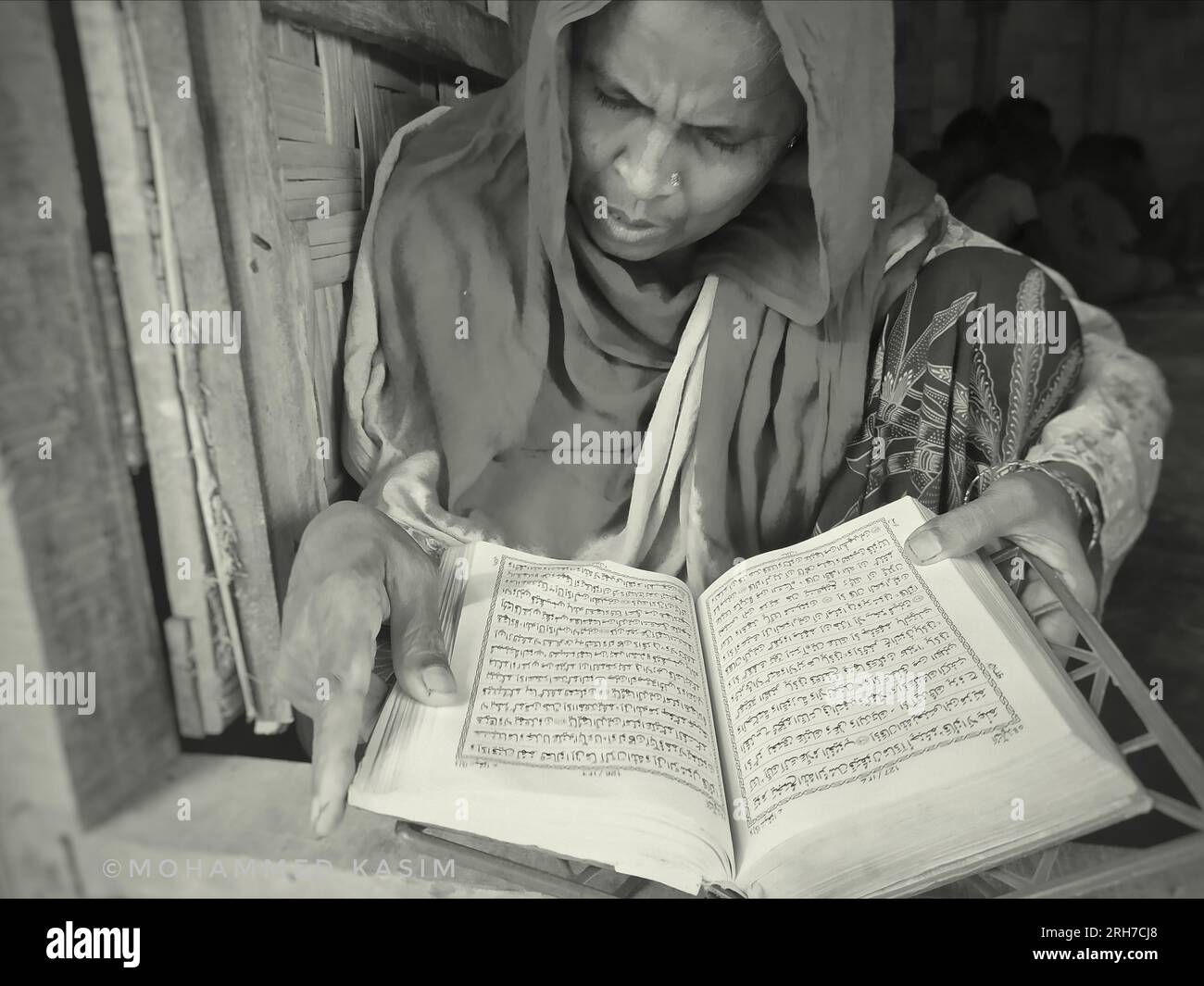A woman reading the quran. Approximately 919,000 Rohingya refugees are living at the Kutupalong and Nayapara camps in Cox’s Bazar region — which have grown to become some of the largest and most densely populated camps in the world. Bangladesh. Stock Photo