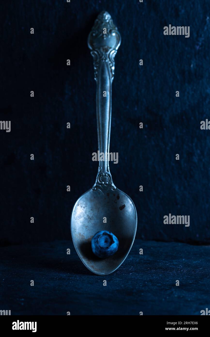 Old spoon with blueberries. Silver spoon and blueberry. Front view ...