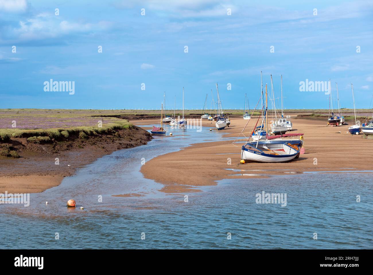Boats at low tide in summer lying on the sandbar opposite the holiday resort of Wells-next-the-Sea, North Norfolk, England Stock Photo