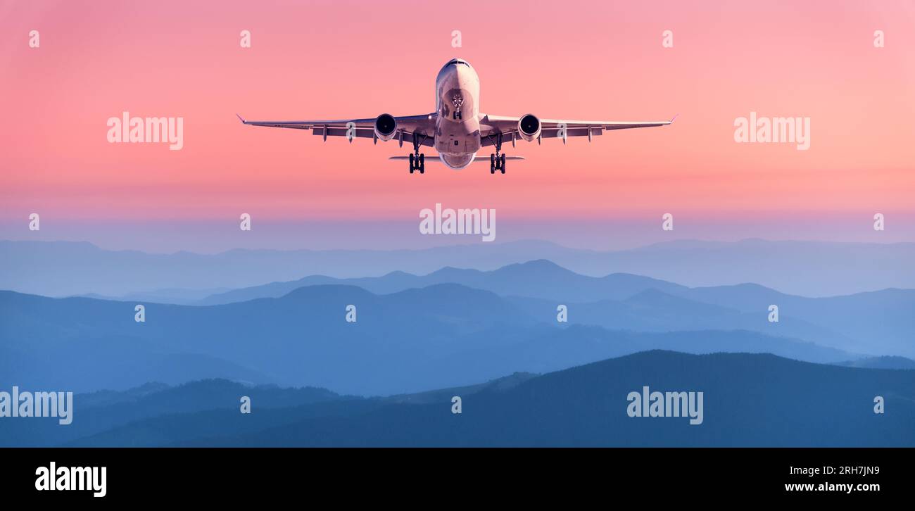 Plane is flying in pink sky at sunset. Passenger airplane Stock Photo ...
