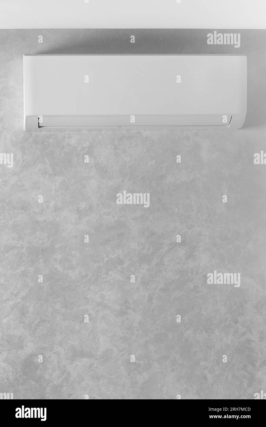 White air conditioner on a gray wall in a house, apartment, copy space