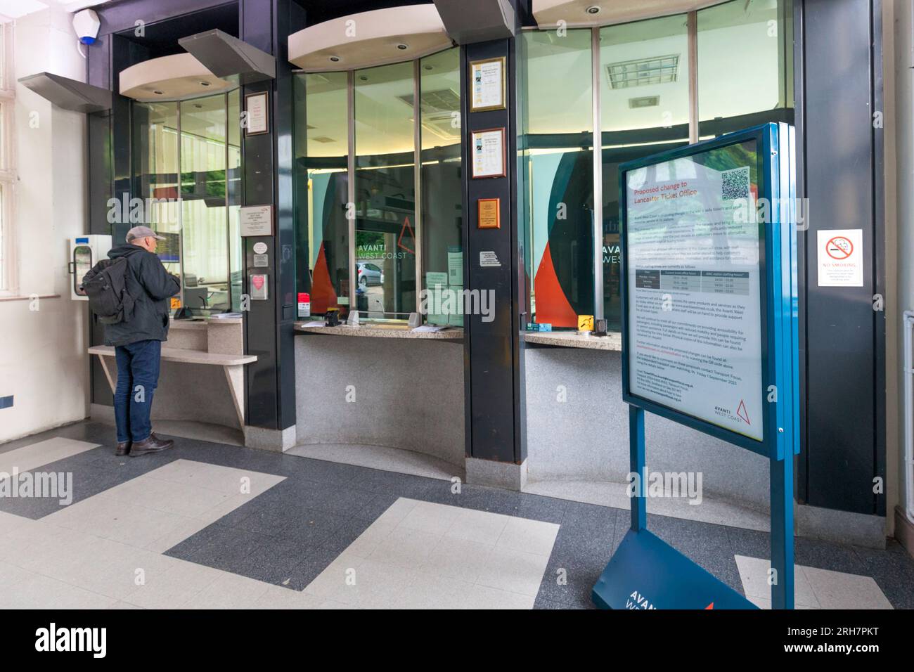 Lancaster railway station ticket office with a passenger buying a