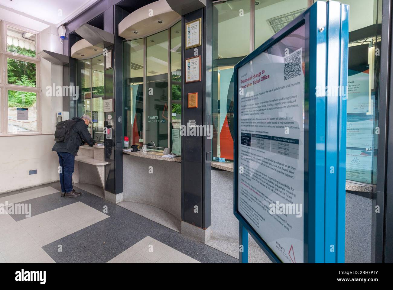 Lancaster railway station ticket office with a passenger buying a