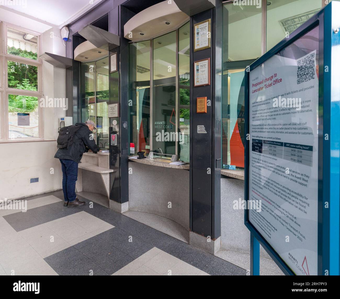 Lancaster railway station ticket office with a passenger buying a