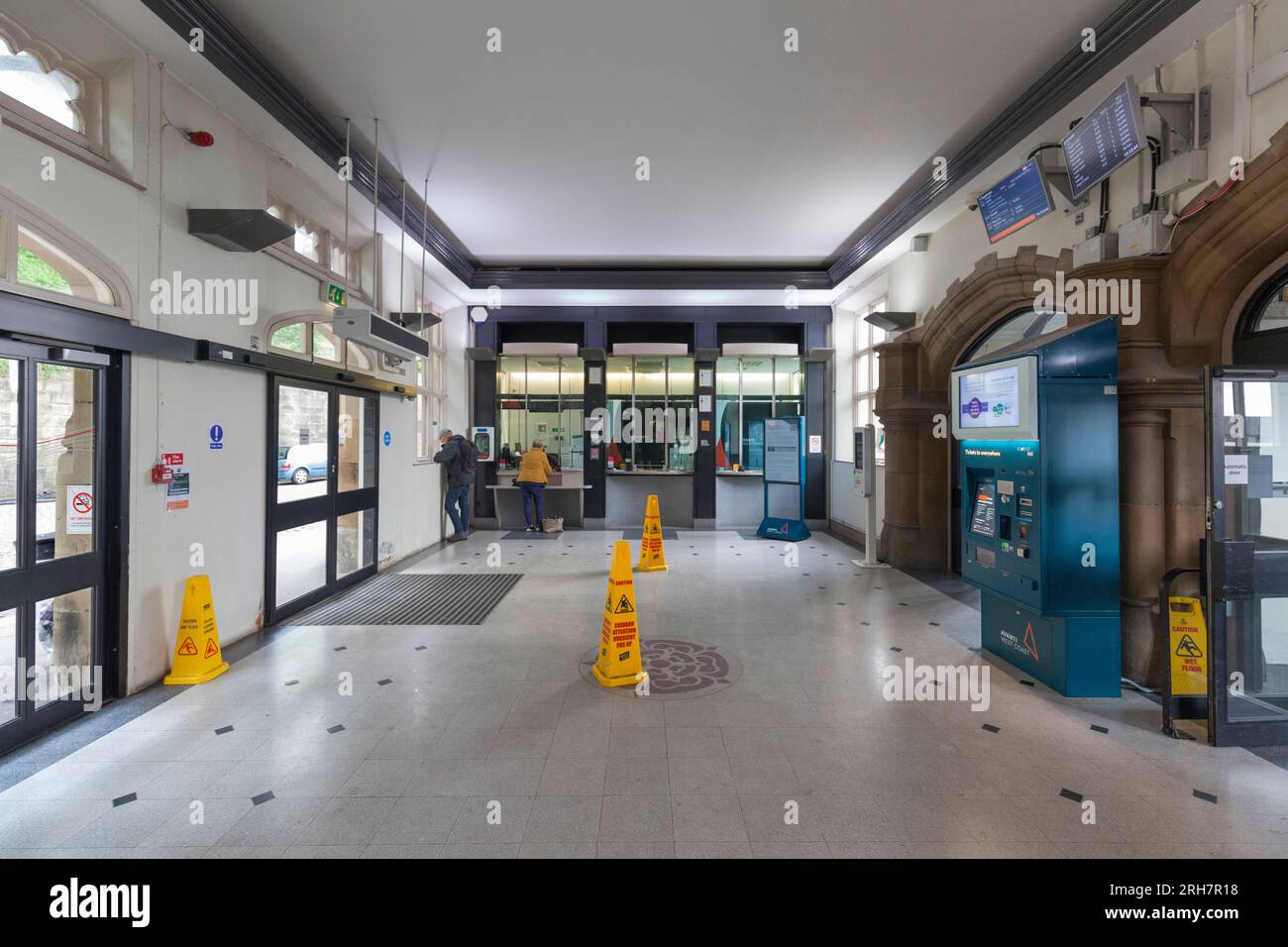 Lancaster railway station ticket office with a passenger buying a