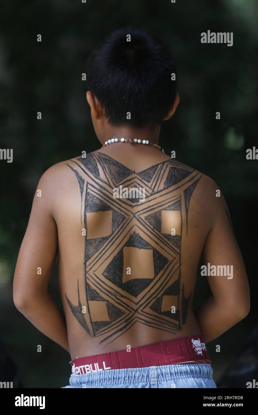 Brazilian indigenous boy portrait with body painted back tatoo with ink. International Day of Indigenous Peoples celebration Stock Photo