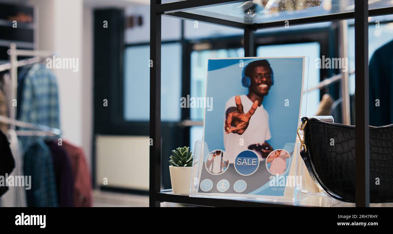 Selective focus of clothing store flyer in empty modern boutique