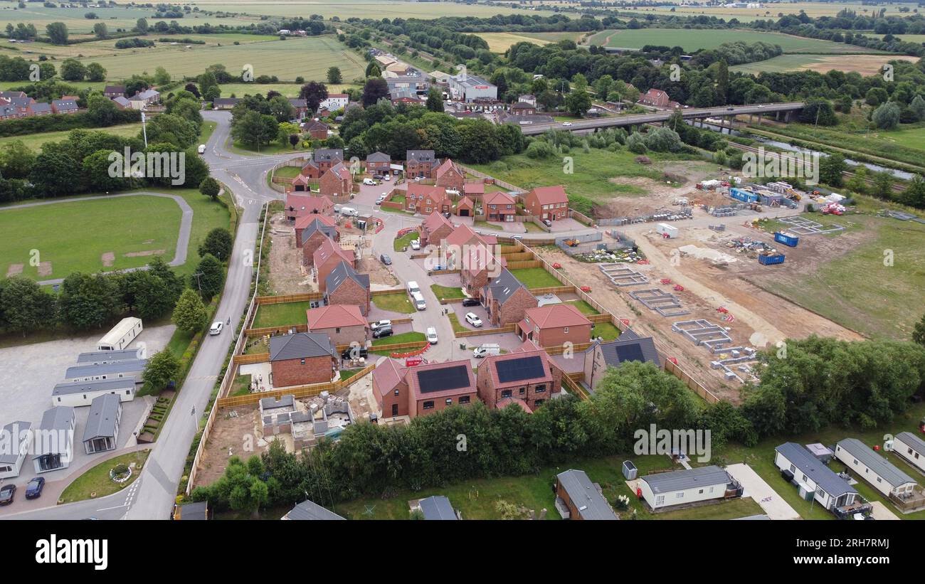 Drone view at altitude of a large estate of beautiful new houses being constructed by craftsmen. Stock Photo