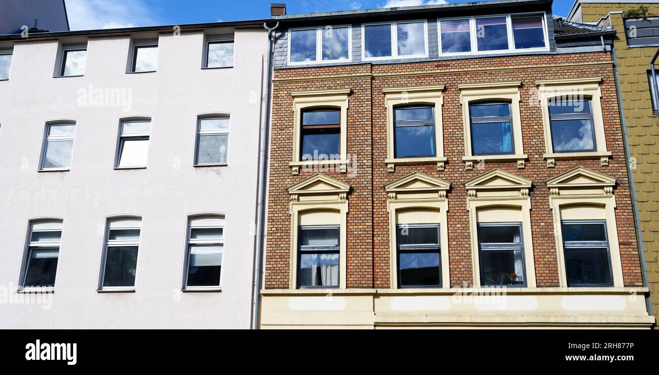 the contrast of a beautifully preserved ornate brick house and a plain modern renovated house of the same year of construction from the end of the 19t Stock Photo