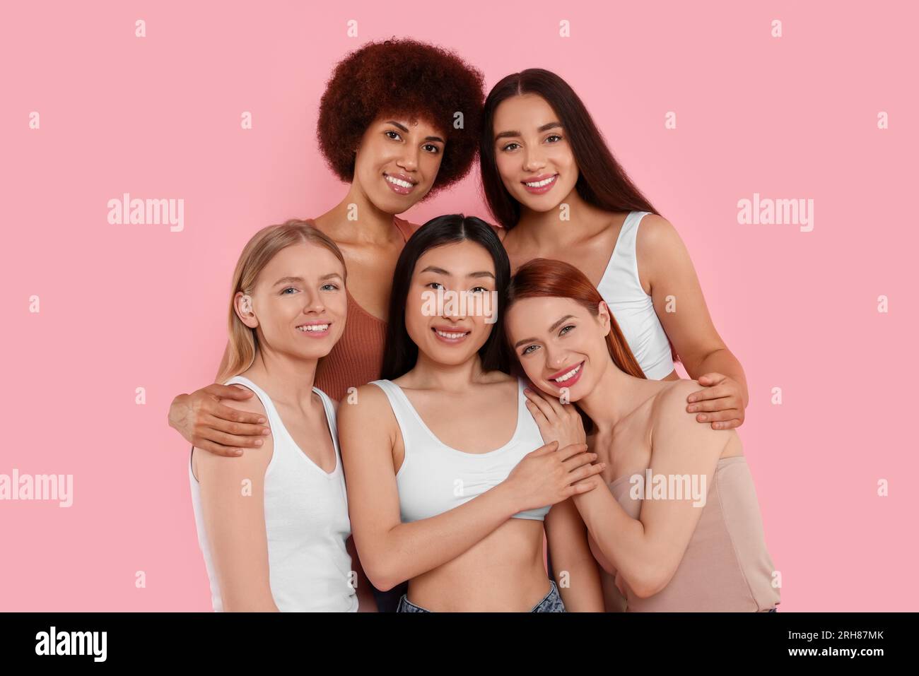 Portrait of beautiful young women on pink background Stock Photo - Alamy