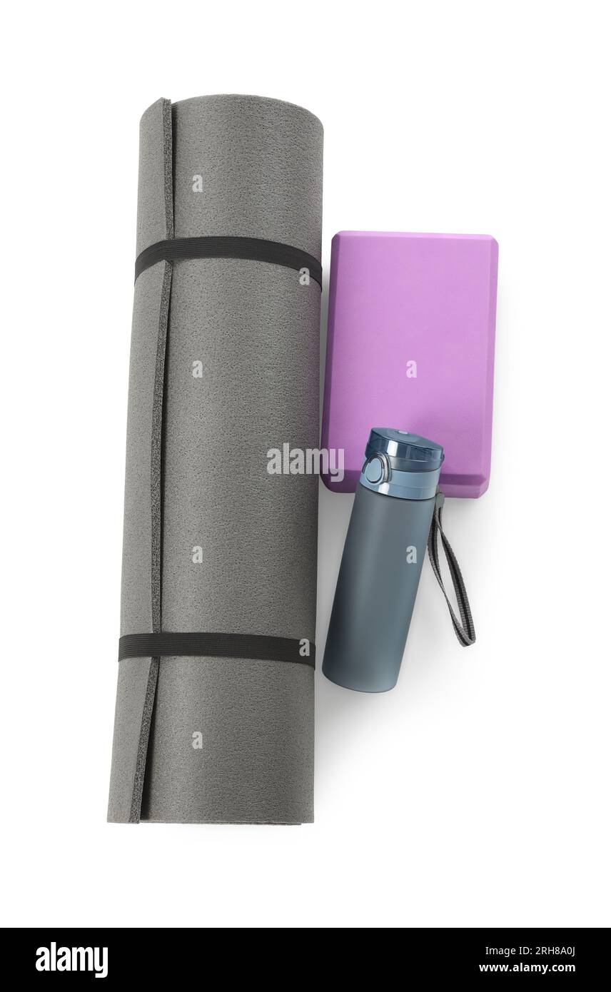 Grey exercise mat, yoga block and bottle of water isolated on white ...