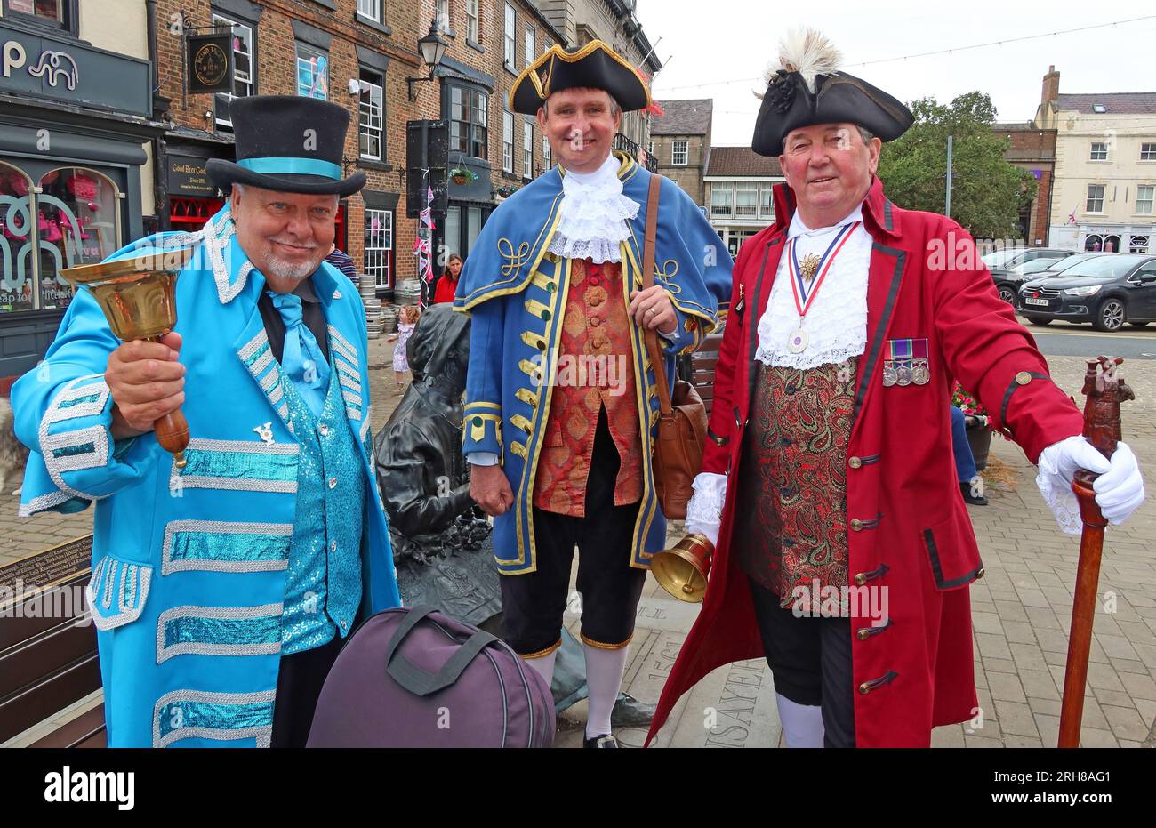 Three bell ringers town criers , in the marketplace, Knaresborough town centre, North Yorkshire, England, UK, HG5 8AL Stock Photo