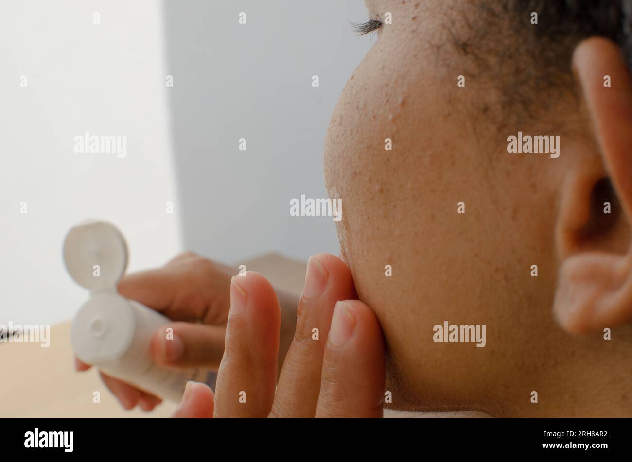 Gestures of care, female hands using moisturizing cream on the face(06)