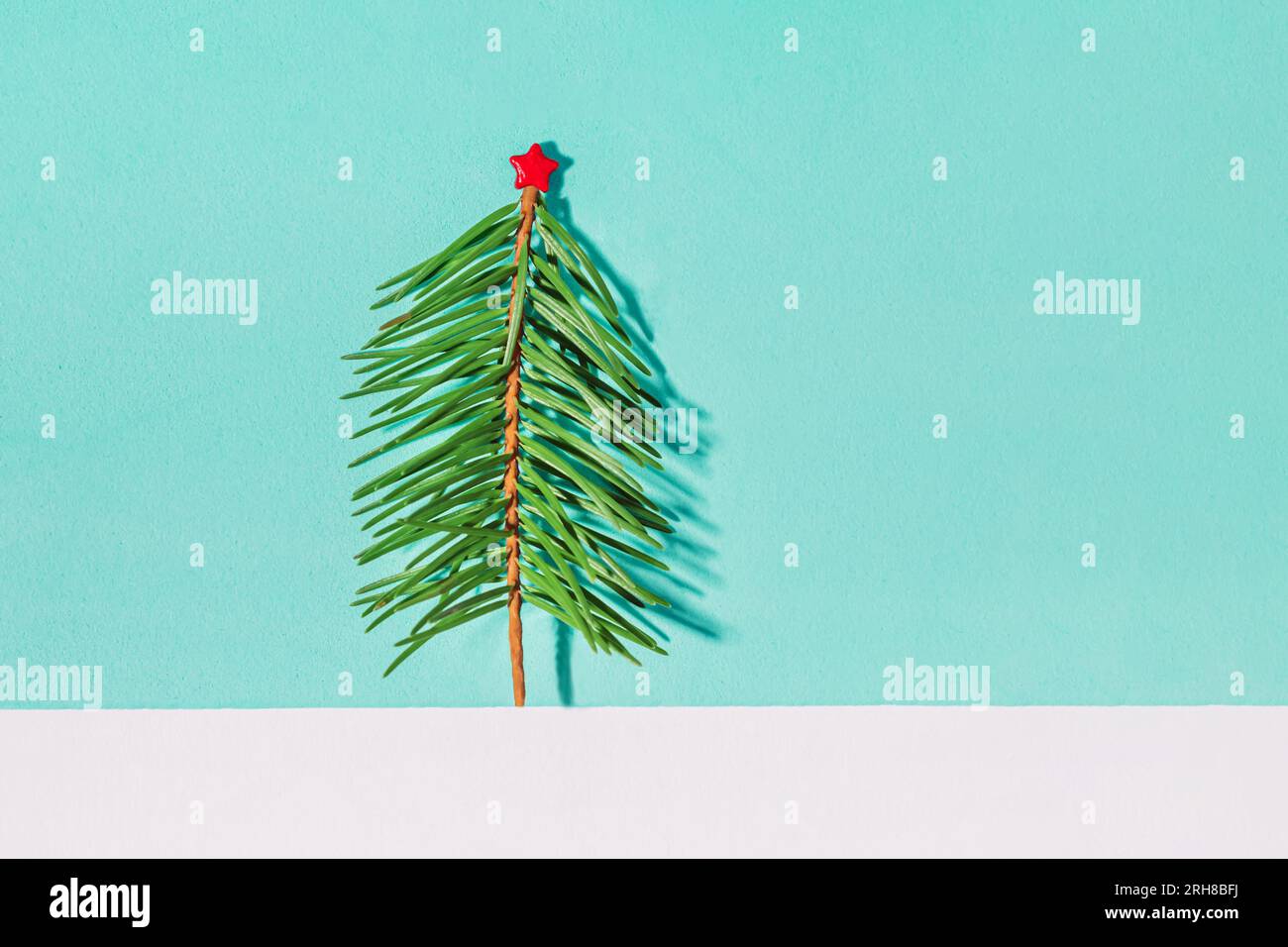 Small Christmas tree with red star on blue background Stock Photo