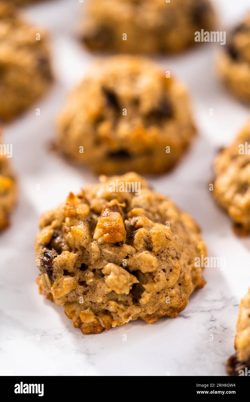 Scooping cookie dough with dough scoop into a baking sheet lined with  parchment paper to bake soft oatmeal raisin walnut cookies Stock Photo -  Alamy