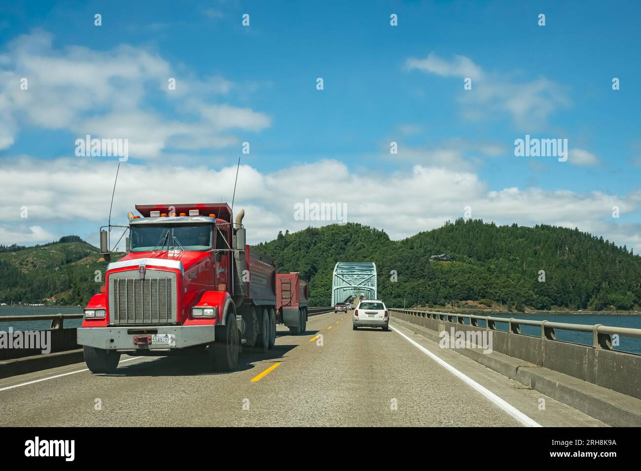 Red truck semi truck with trailer driving on highway. Big industrial truck transporting cargo