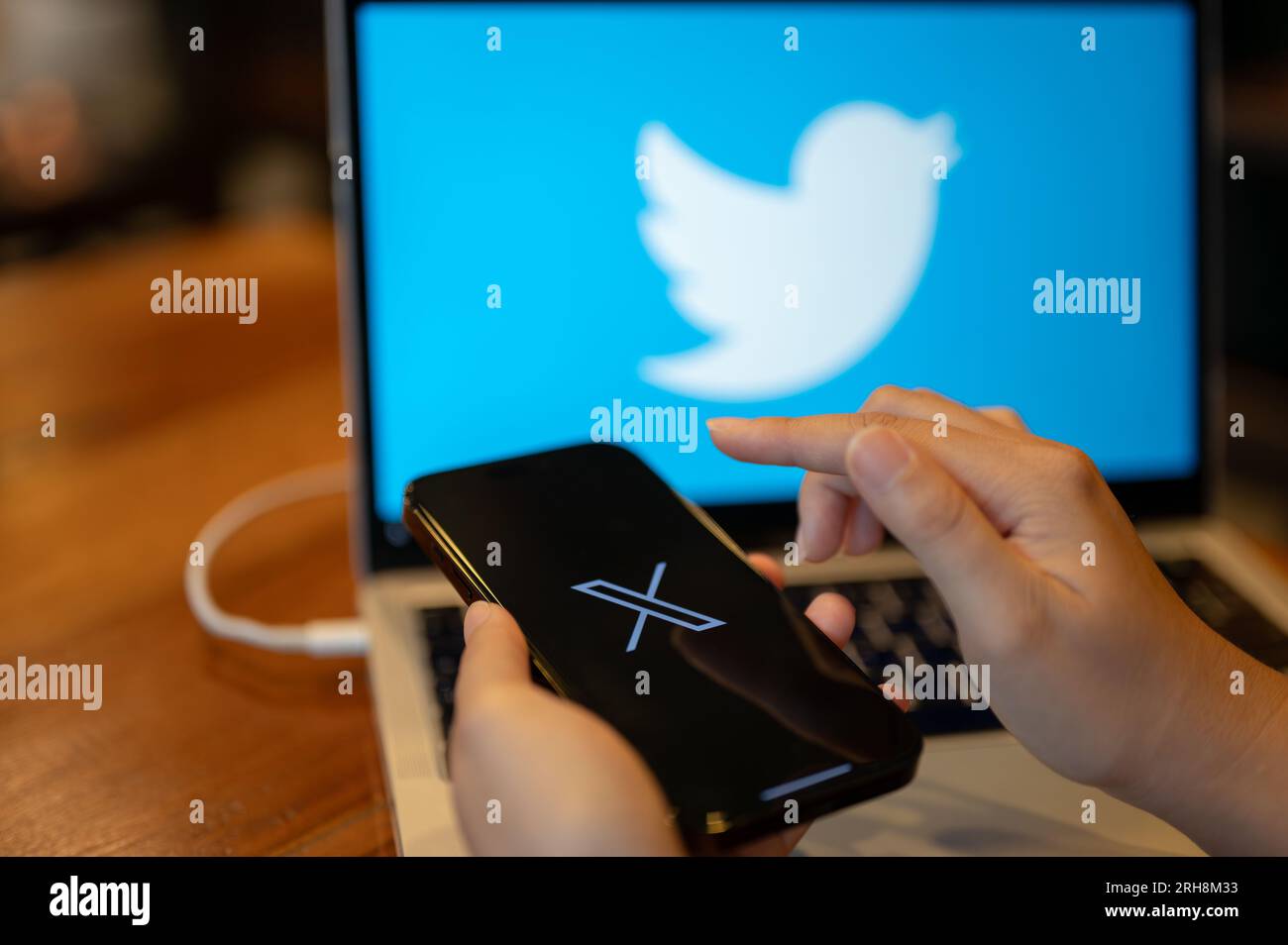 Chiang Mai, Thailand - Aug 14 2023: A female using X new twitter application on her iPhone14 at her workspace. close-up image of a new Twitter X appli Stock Photo