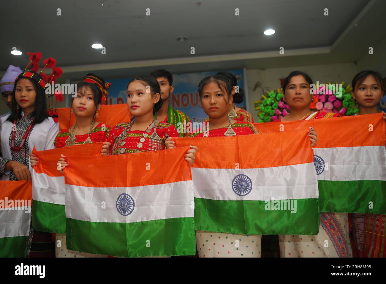 Indigenous girls holding the national flag during a cultural program on
