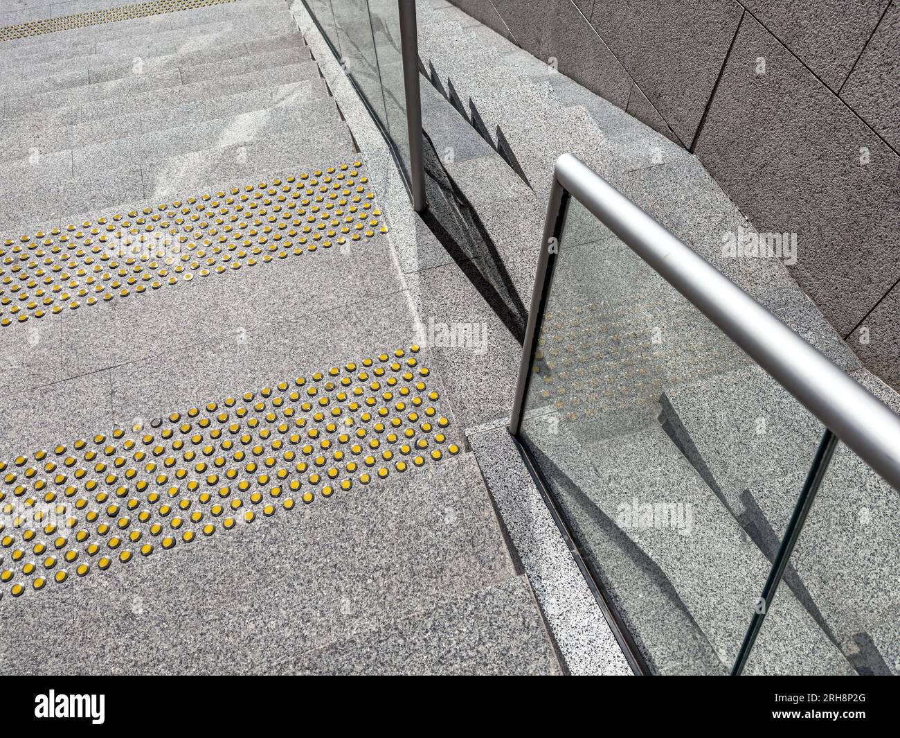 yellow tactile indicators on stairs for people with disabilities. detail of modern outdoor staircase. Stock Photo