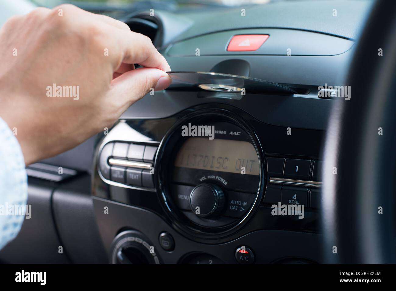 The man inserting CD to CD player in the car. Car audio system concept