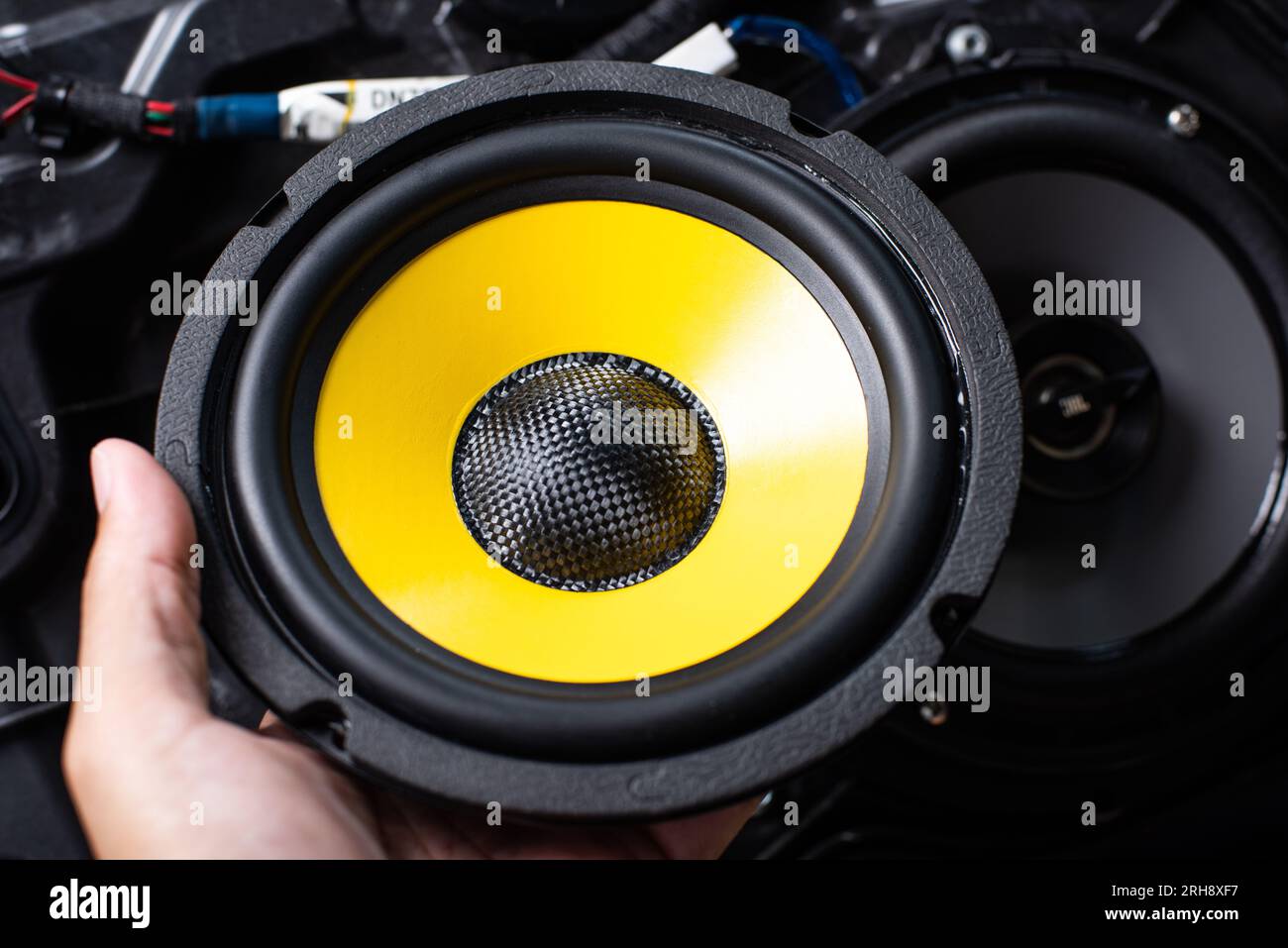 The black audio loudspeaker with yellow diaphragm. Car audio installation concept. Stock Photo