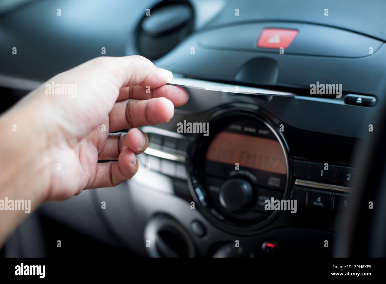 The man inserting CD to CD player in the car. Car audio system concept
