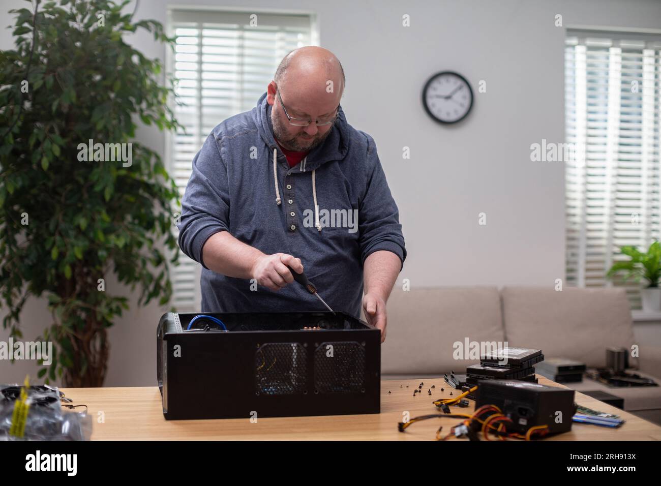 IT specialist repairs desktop computer that stands on desk Stock Photo