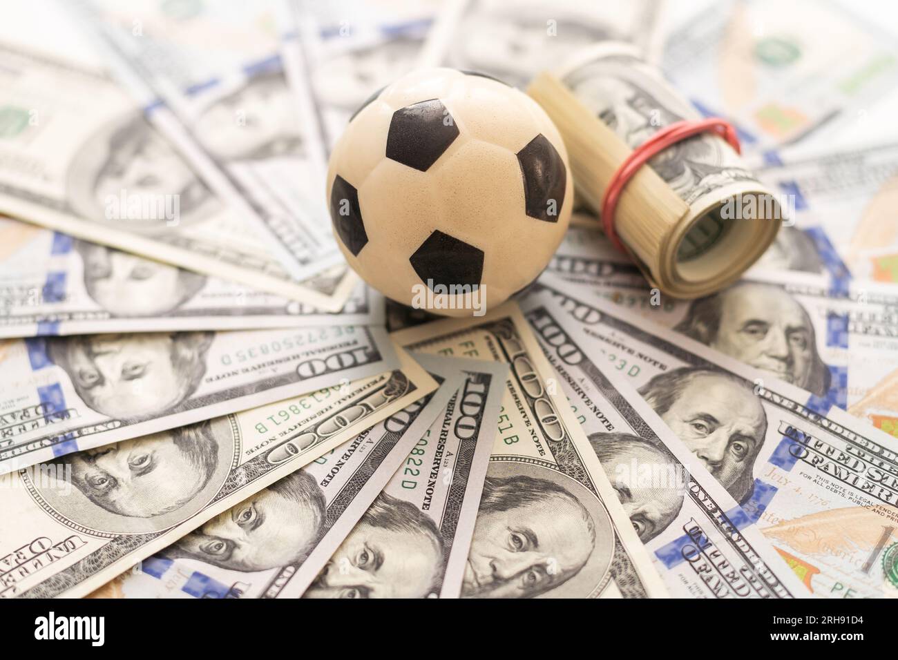 Leather soccer ball on the field of background paper dollar bills Stock