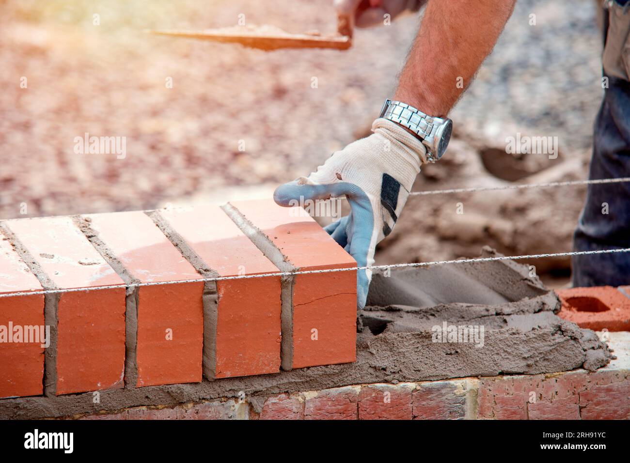 Industrial bricklayer laying bricks on cement mix on construction site closeup Stock Photo Alamy