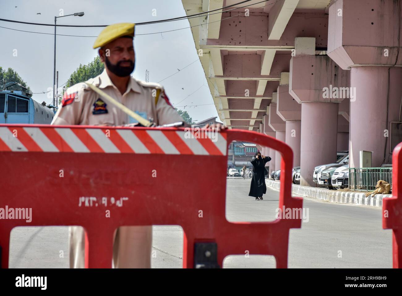 A policeman standing alert at the temporary check-post during the India's 77th Independence Day in Srinagar. Stock Photo