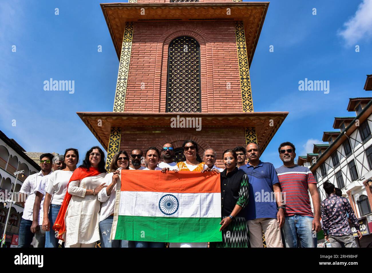 Indian tourists pose with an Indian national flag during the India's 77th Independence Day in Srinagar. Stock Photo
