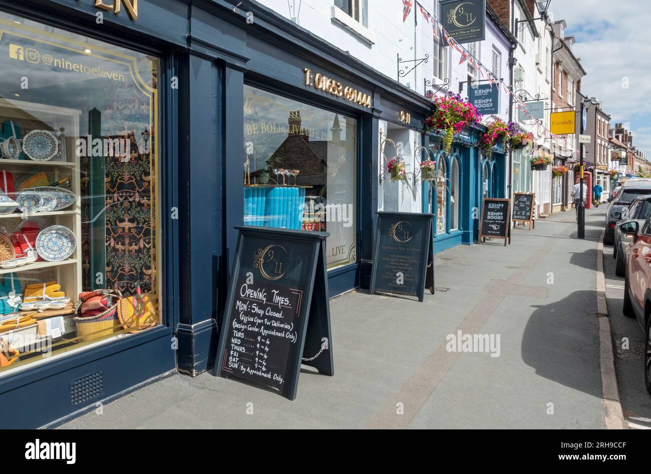 Row of shops stores local independent businesses with A Boards outside  summer Market Place Malton North Yorkshire England UK GB Great Britain Stock Photo