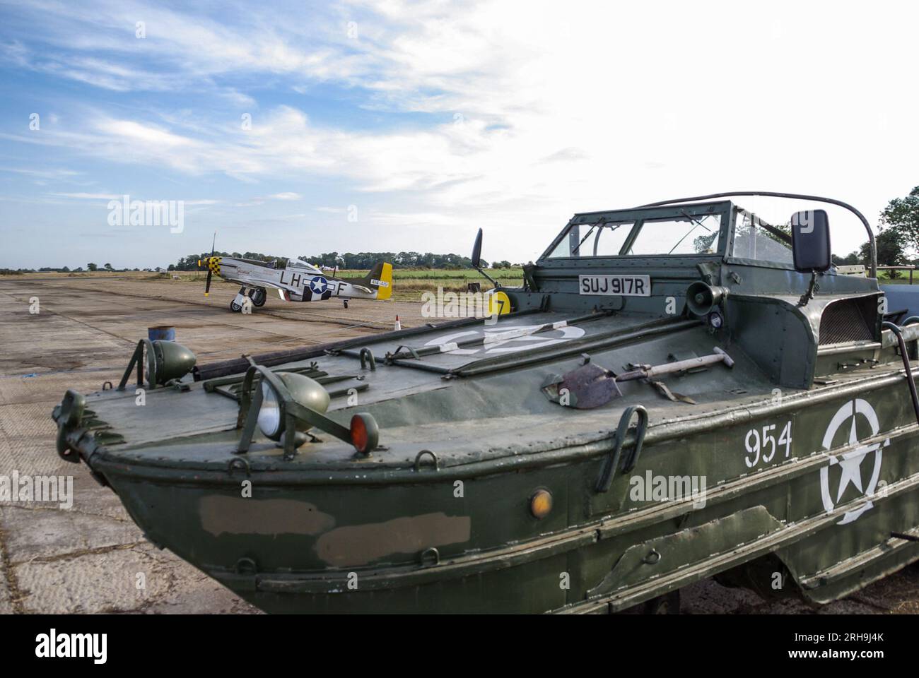 American DUKW amphibious vehicle at a wings & wheels event at the rural airfield of Shipdham, formerly WWII RAF Shipdham, in Norfolk, UK. P-51 plane Stock Photo