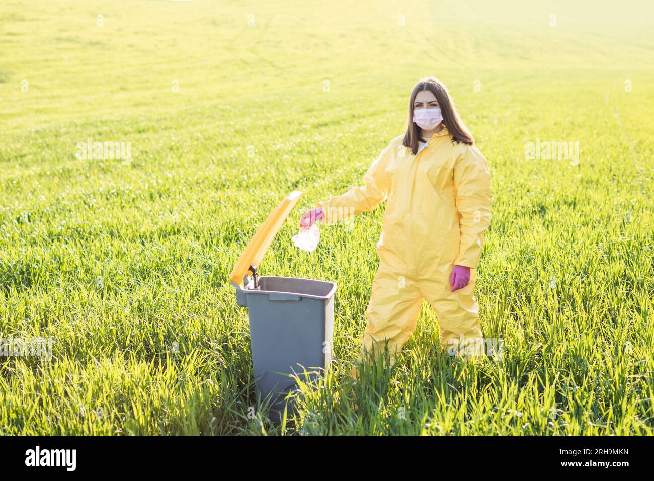 Hand throwing away plastic bottle in nature. Environmental damage by