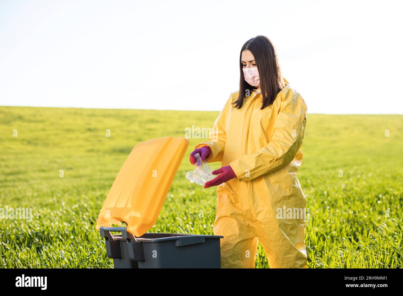Hand throwing away plastic bottle in nature. Environmental damage by