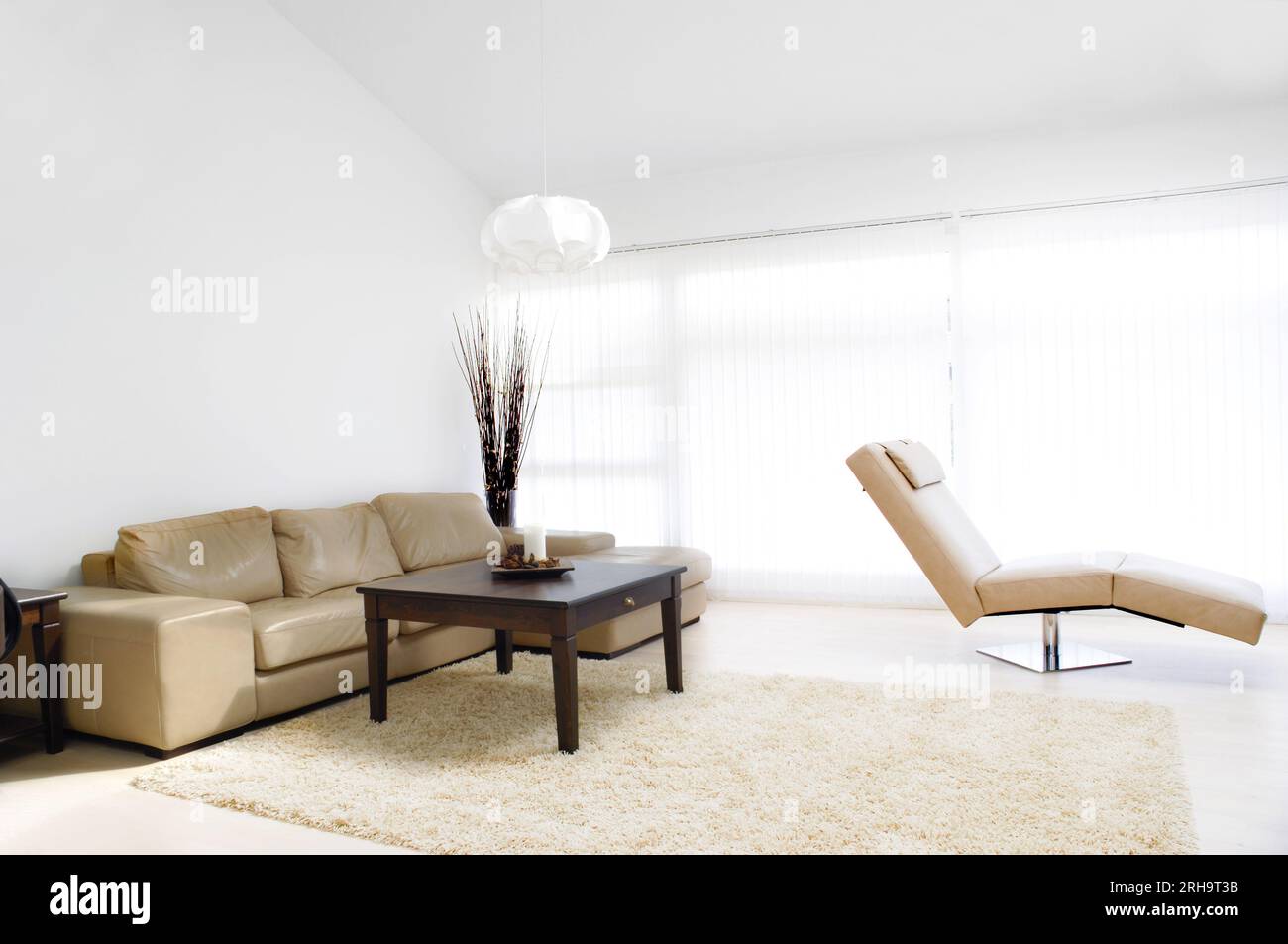 A modern living room with table, sofa and armchair Stock Photo - Alamy