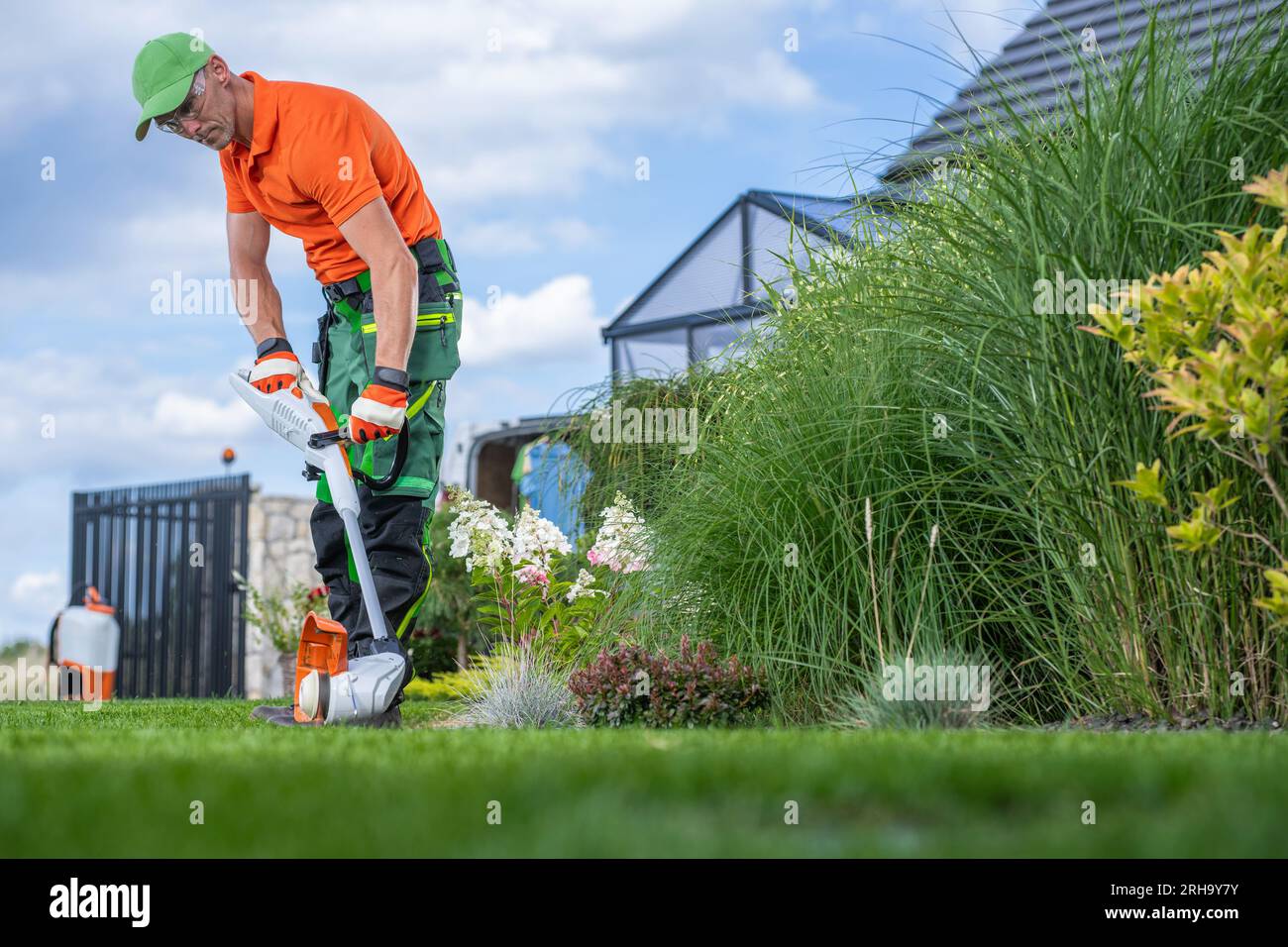 Caucasian Garden Owner in His 40s and the Lawn Edger Job. Keeping the