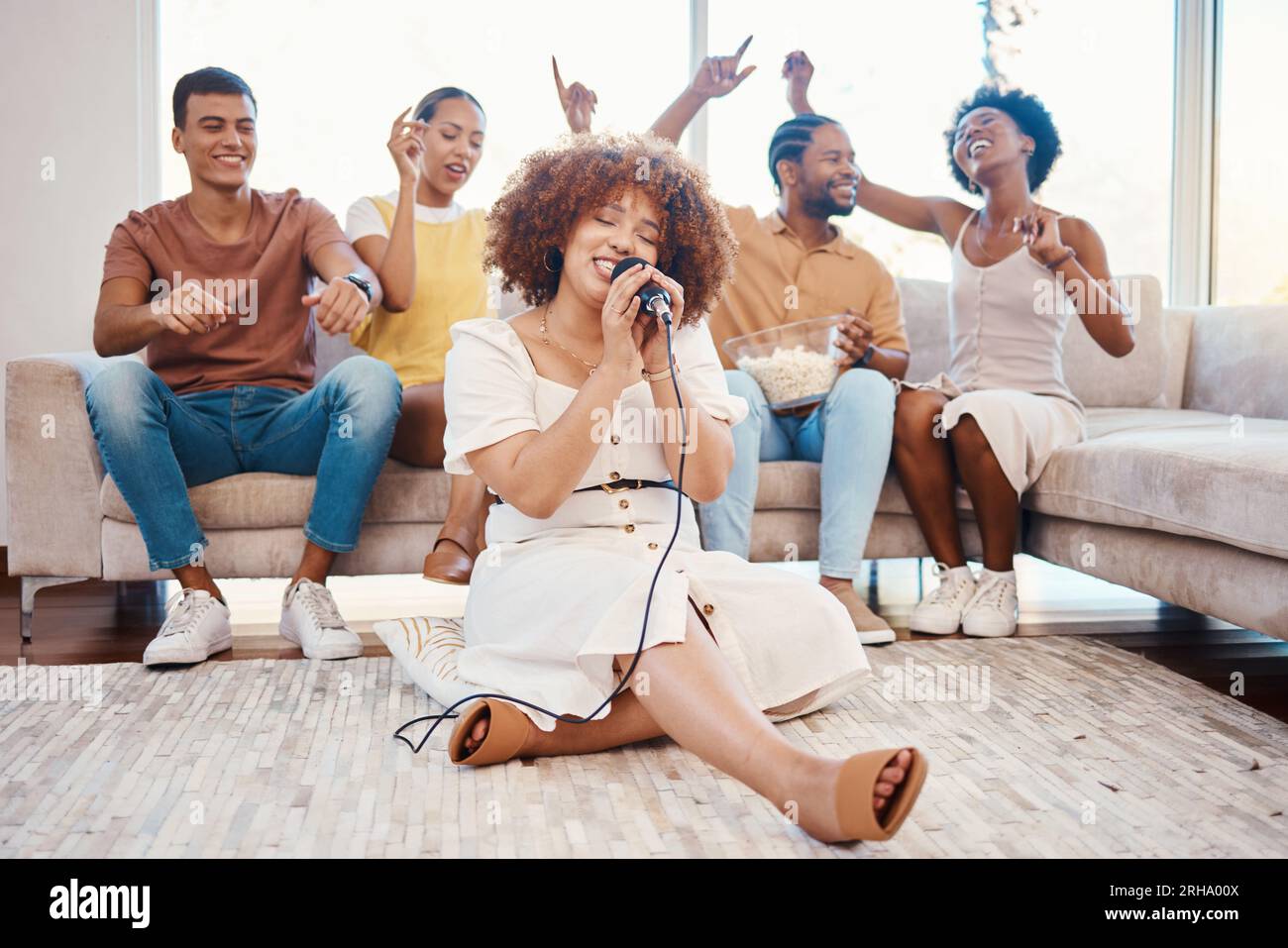 Microphone, friends or happy woman singing in home living room together in party on holiday vacation break. Girl singer, men or group of funny women Stock Photo