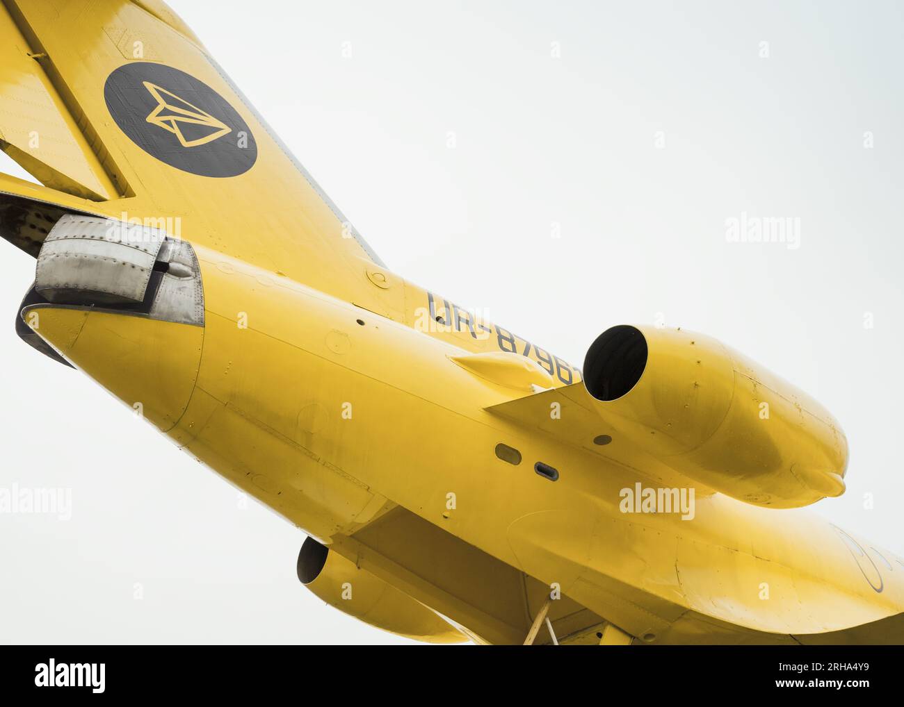 empennage of soviet trijet plane Yak-40. Tail section of yellow regional jet - view from below. Stock Photo