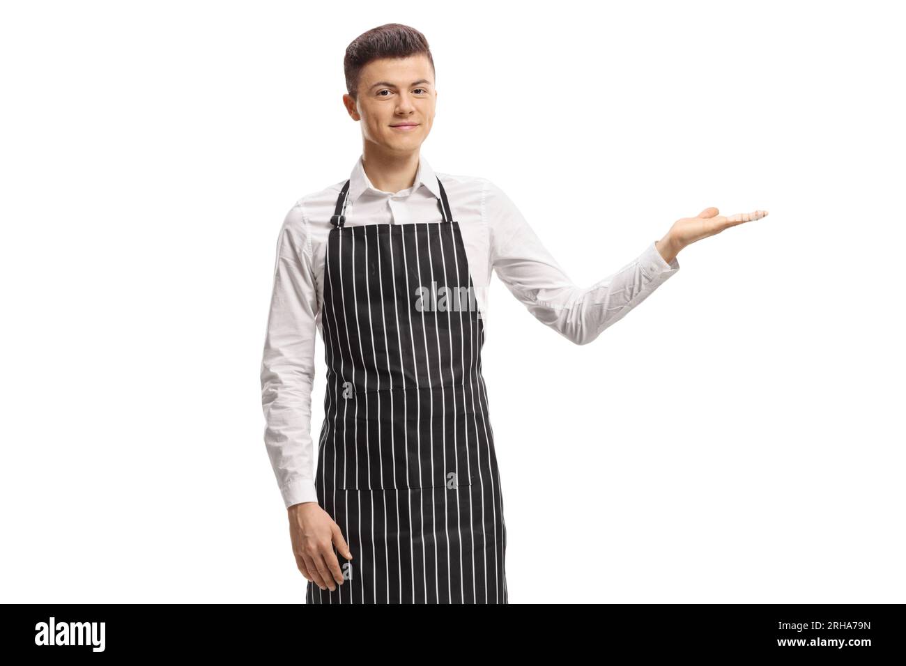 Young male waiter with an apron pointing with hand isolated on white background Stock Photo