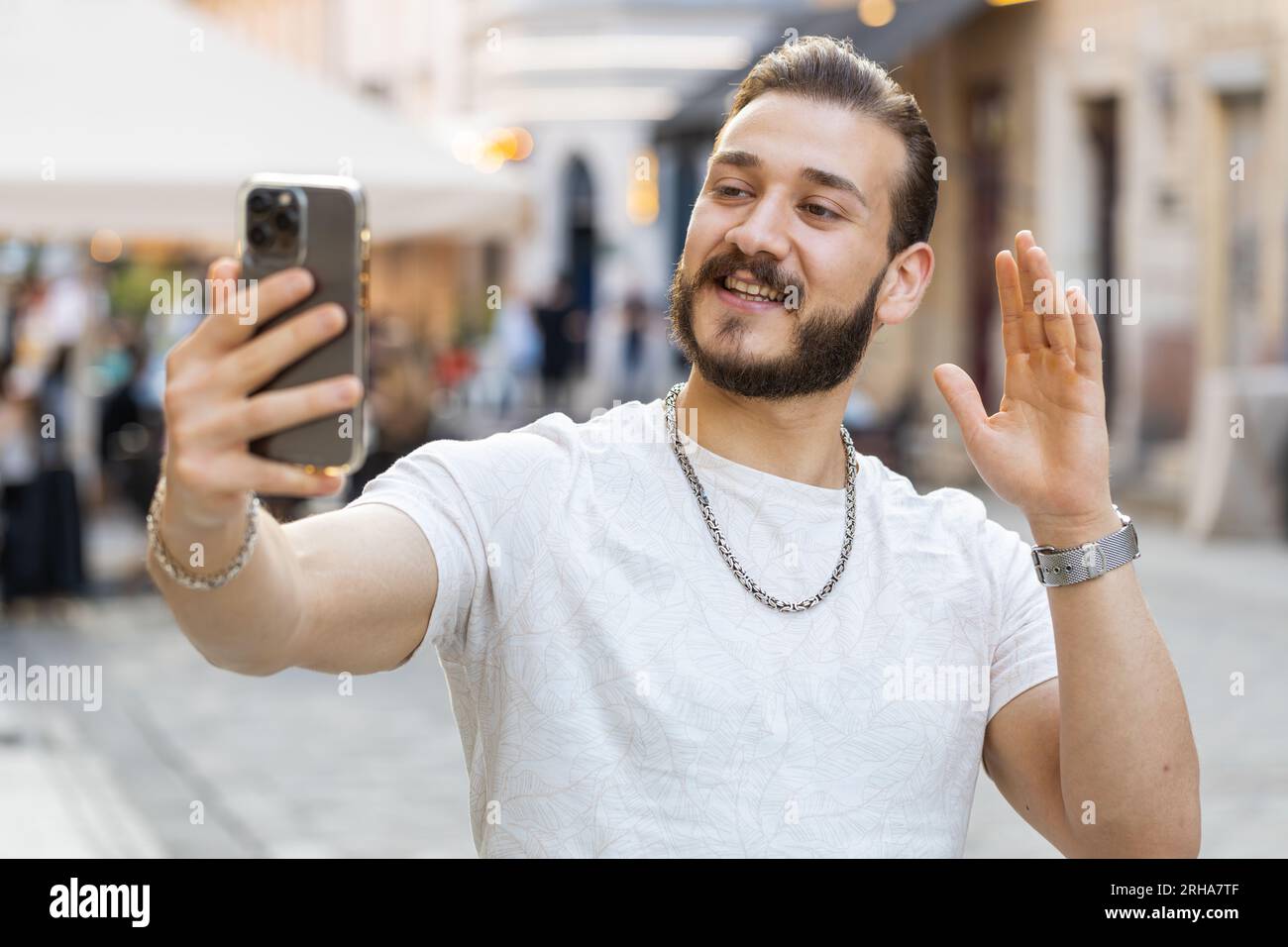 Bearded young man blogger taking selfie on smartphone, communicating video  call online with subscribers, recording stories for social media vlog  outdoors. Guy walking in urban sunshine city street Stock Photo - Alamy