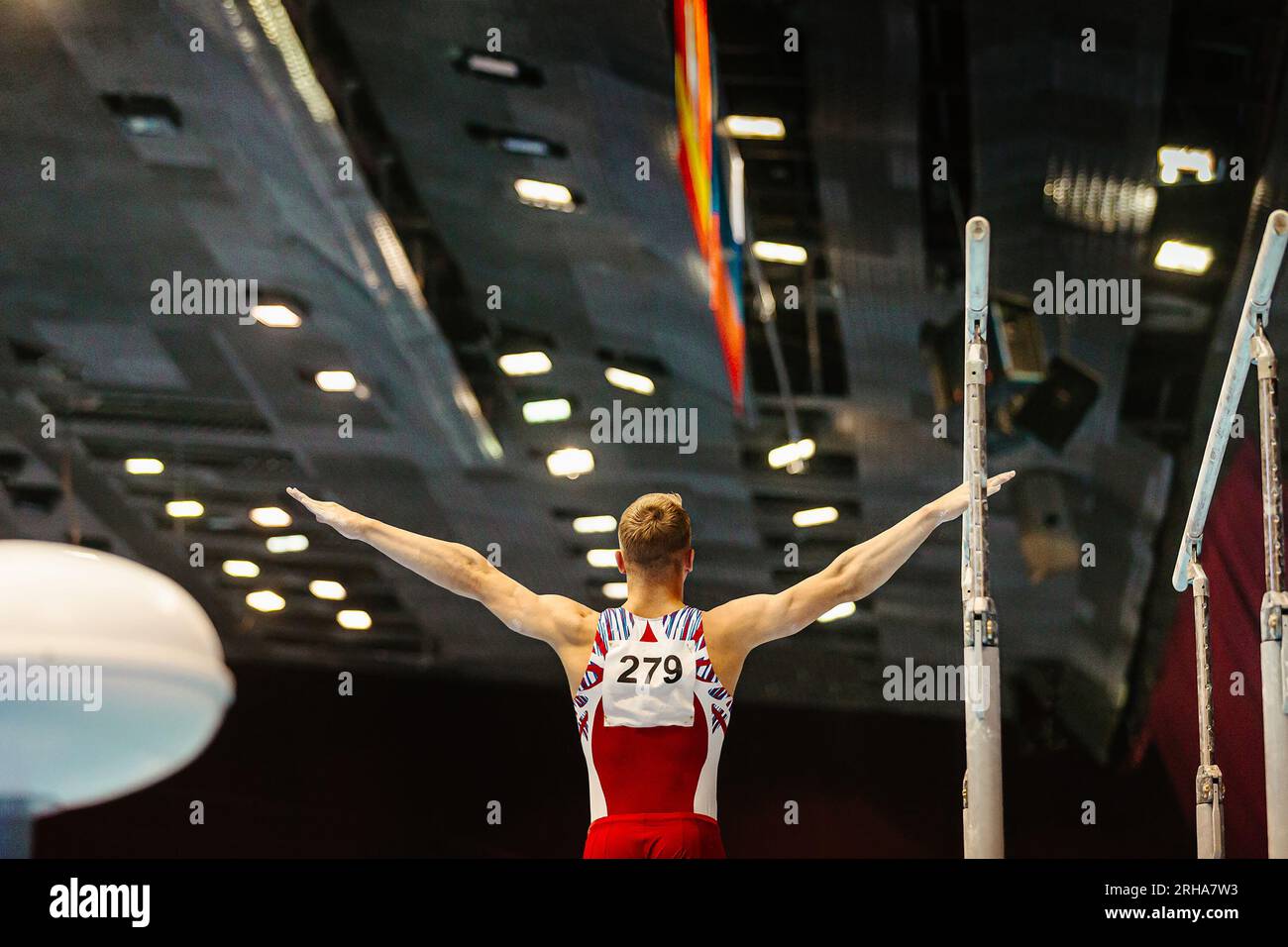 rear view gymnast starting exercise parallel bars in championship
