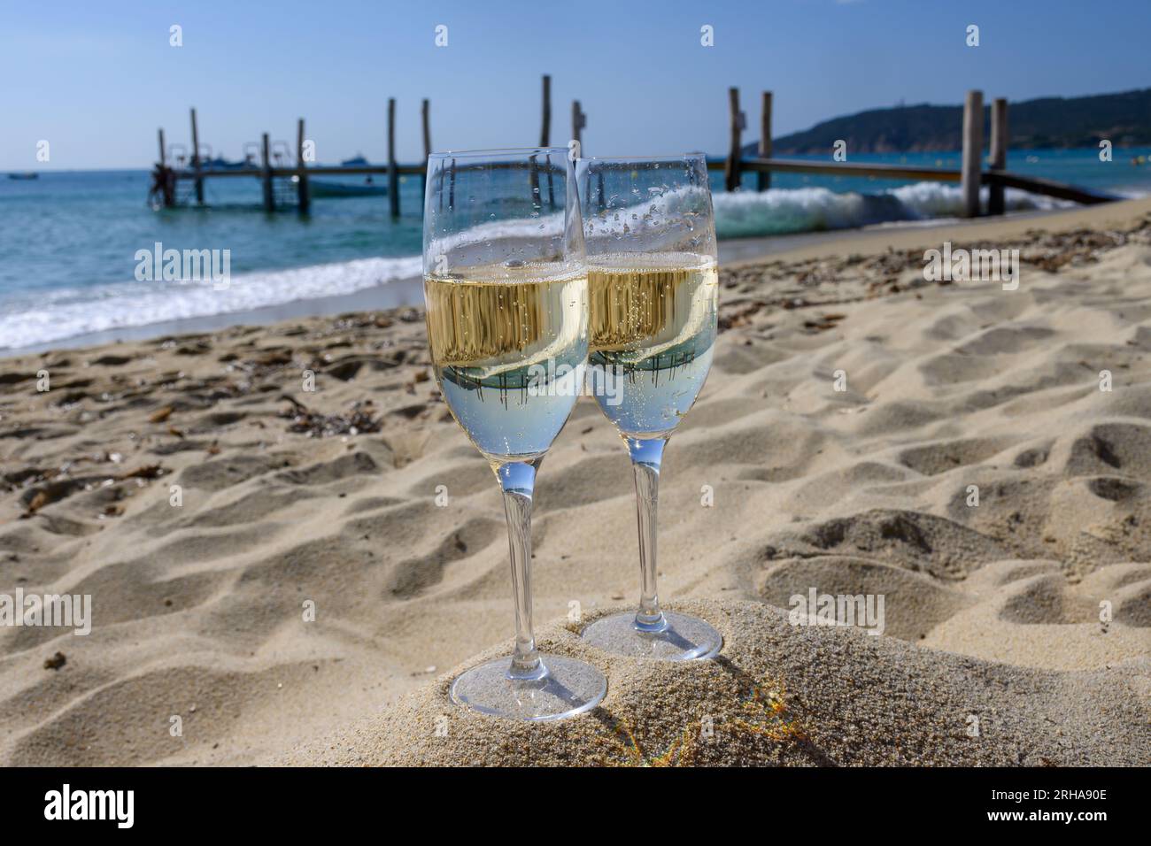 Summer time in Provence, two glasses of cold champagne cremant sparkling wine on famous Pampelonne sandy beach near Saint-Tropez in sunny day, Var dep Stock Photo