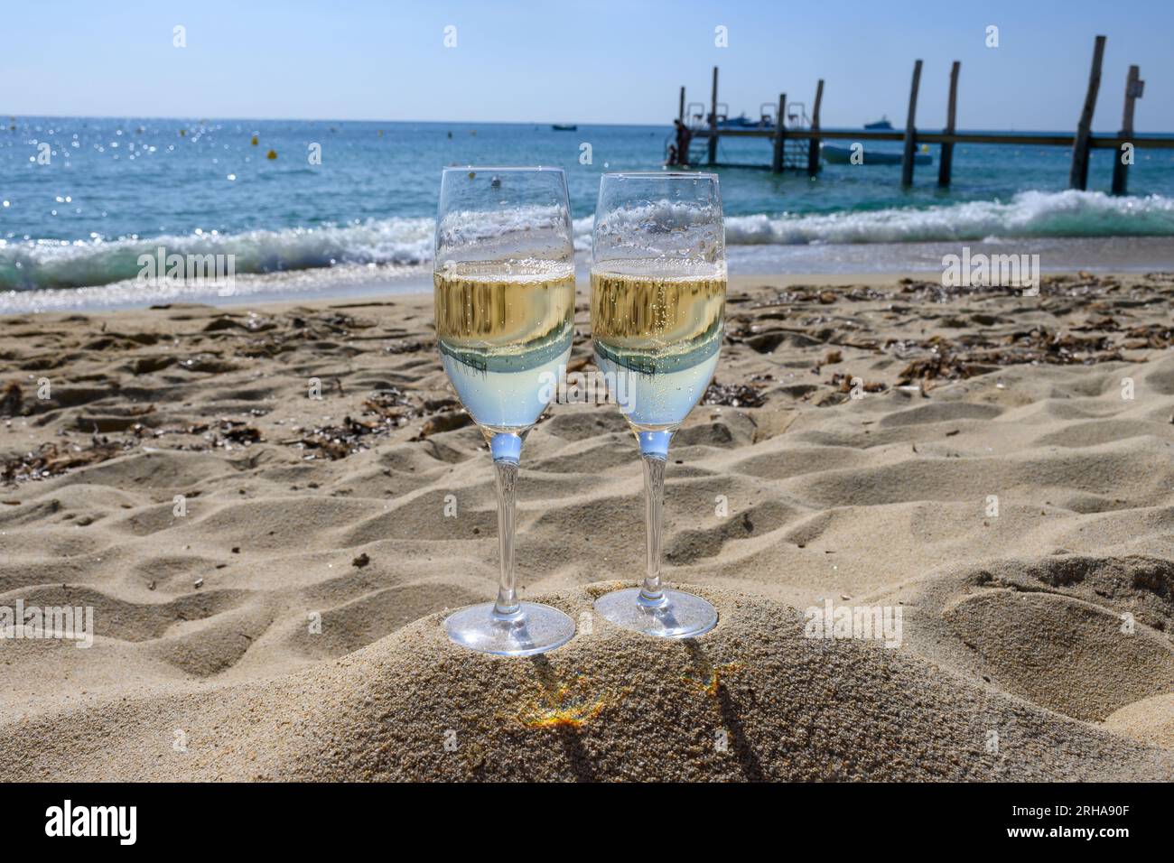 Summer time in Provence, two glasses of cold champagne cremant sparkling wine on famous Pampelonne sandy beach near Saint-Tropez in sunny day, Var dep Stock Photo