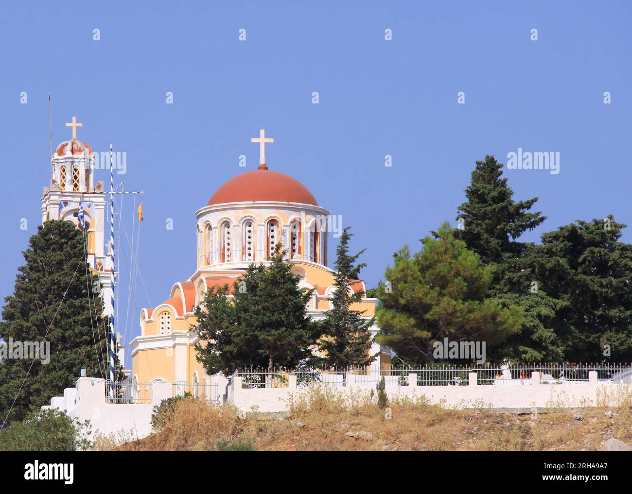 Greek Orthodox Church with Dome and Bell Tower on the Hill in Symi, Greece Stock Photo