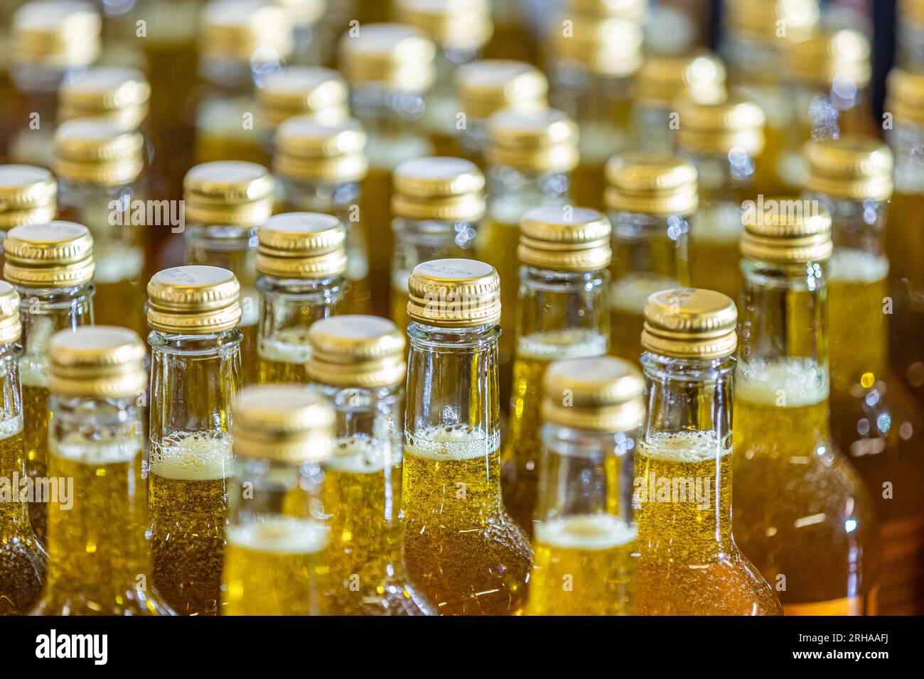 Glass bottles being filled on production line at factory in the UK Stock Photo