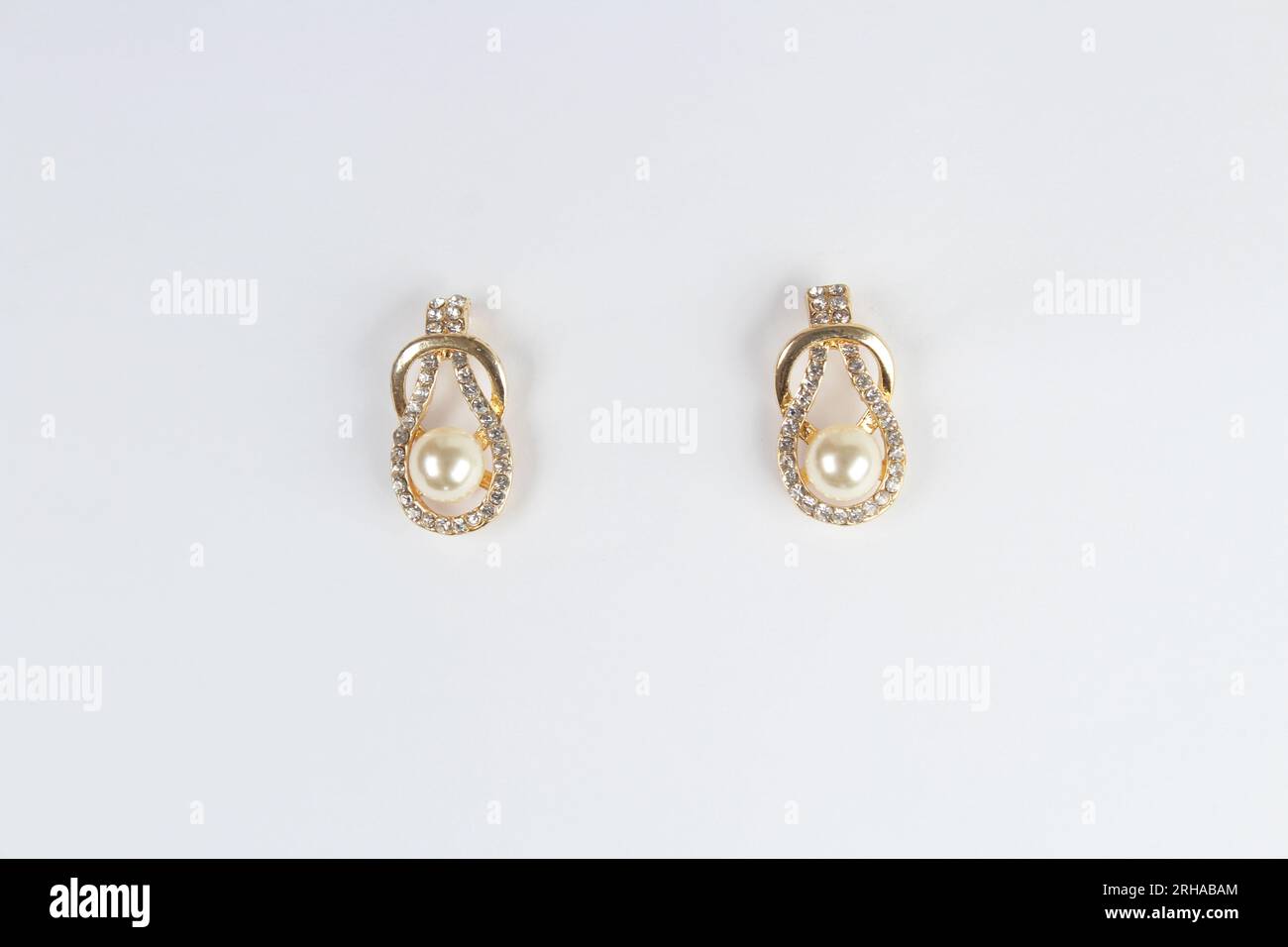 Earring with cream bead isolated on white background. Stock Photo