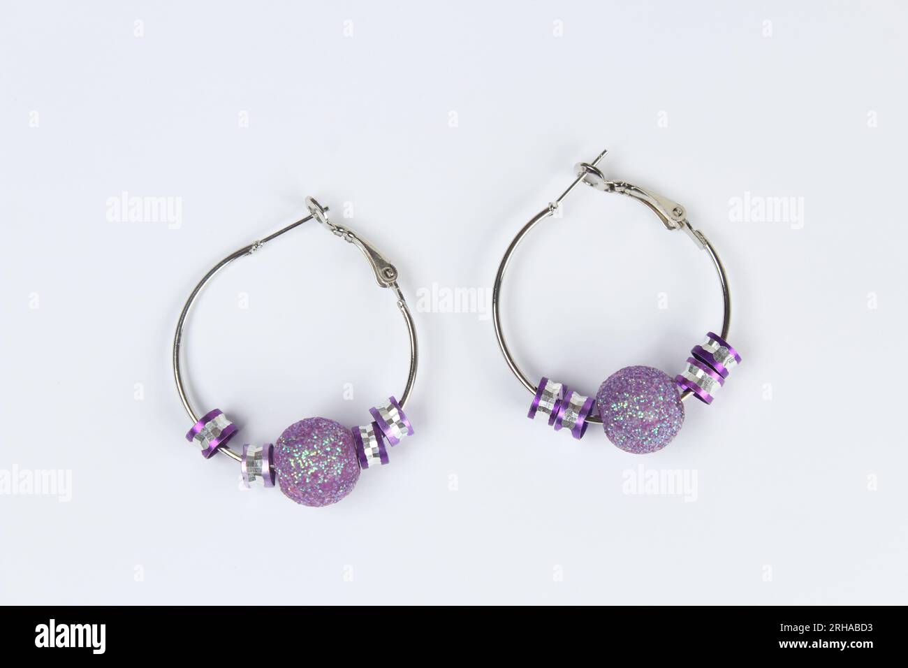 Purple earring isolated on white background. Stock Photo