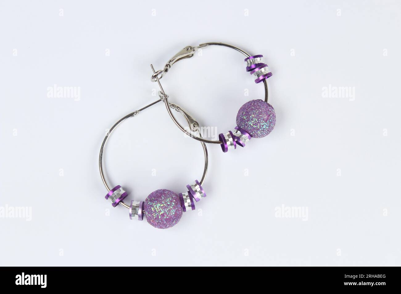 Purple earring isolated on white background. Stock Photo